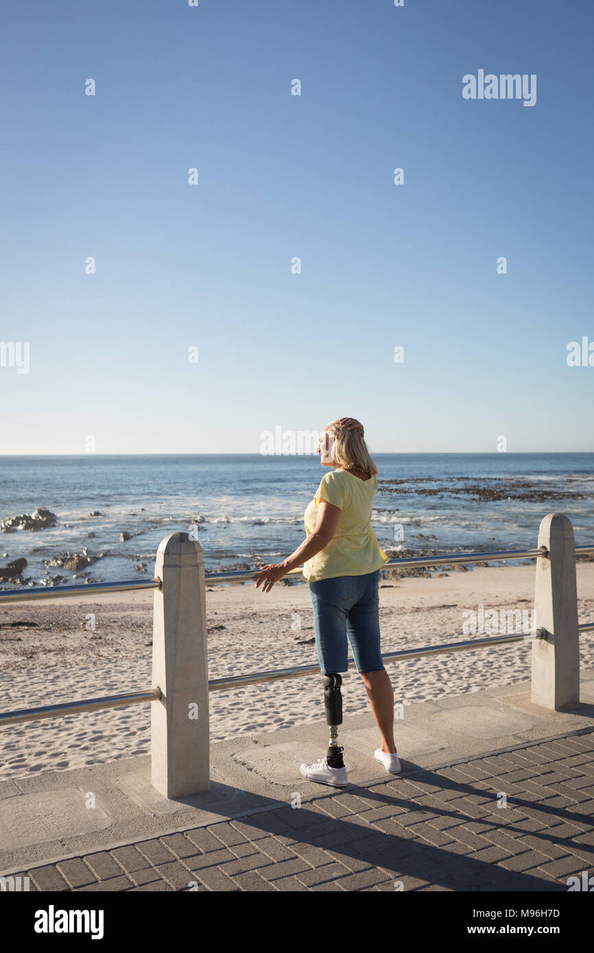 Behinderte Frau, die in der Nähe von Strand Stockfoto
