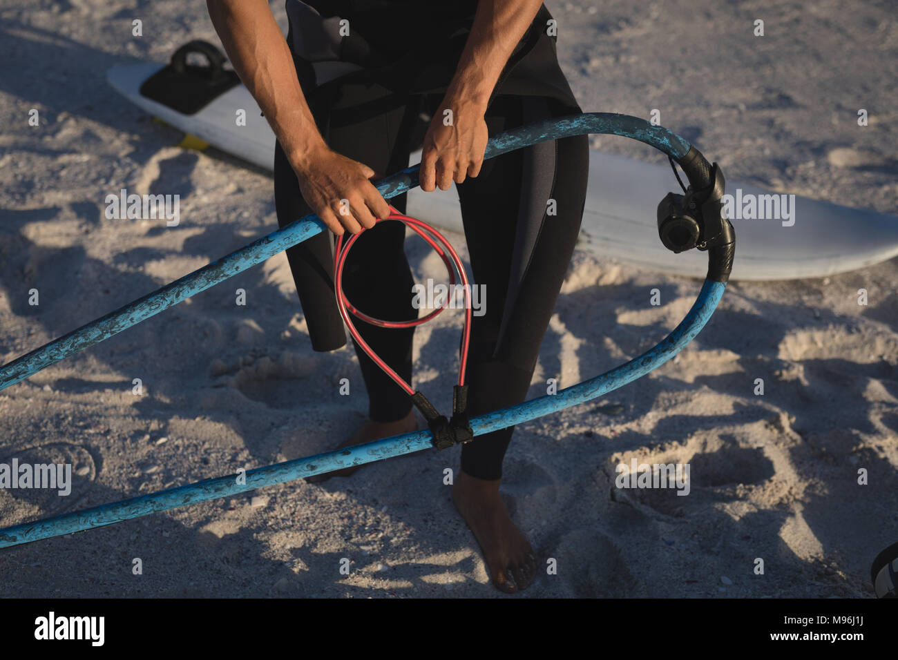 Männliche surfer Vorbereiten eines Drachen am Strand Stockfoto