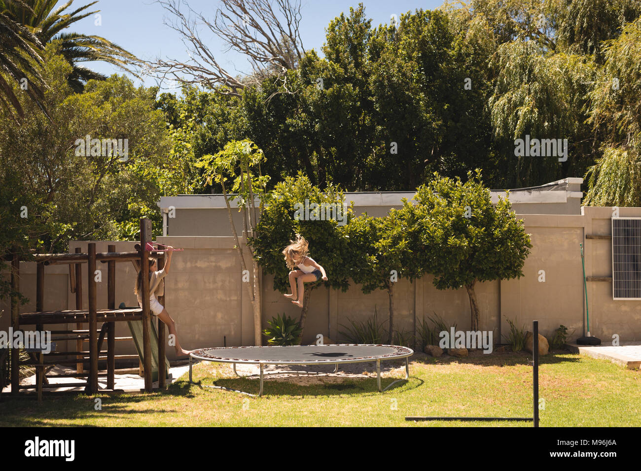 Mädchen springen auf Trampolin im Garten Stockfoto