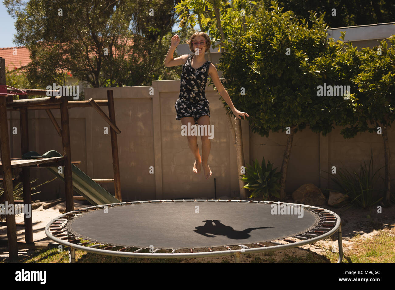 Mädchen Springen auf einem Trampolin im Garten Stockfoto