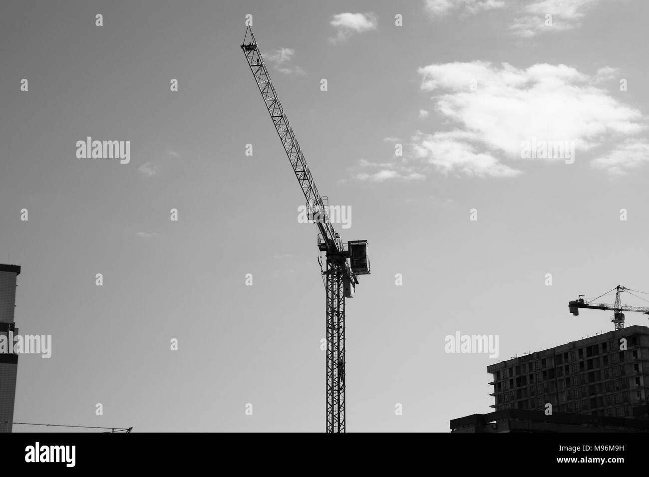 Turm Gebäude Kran gegen den blauen Himmel und Sonne. Der Bau von neuen Gebäuden mit einem Kran. Turmdrehkran. Stockfoto