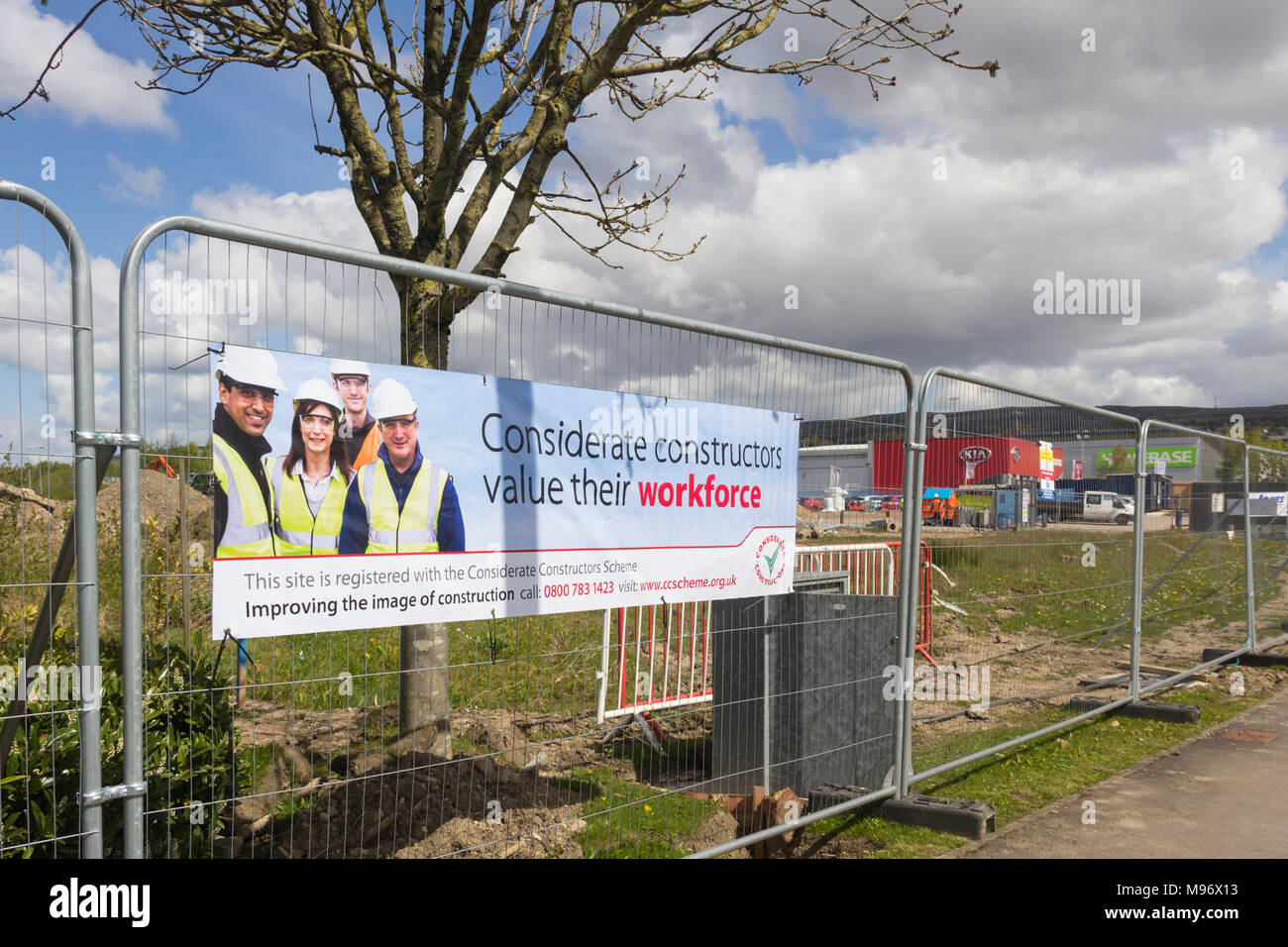 Rücksichtsvoll Konstruktoren banner befestigt die Umzäunung einer Baustelle Middlebroo Retail Park in der Nähe von Bolton. Stockfoto