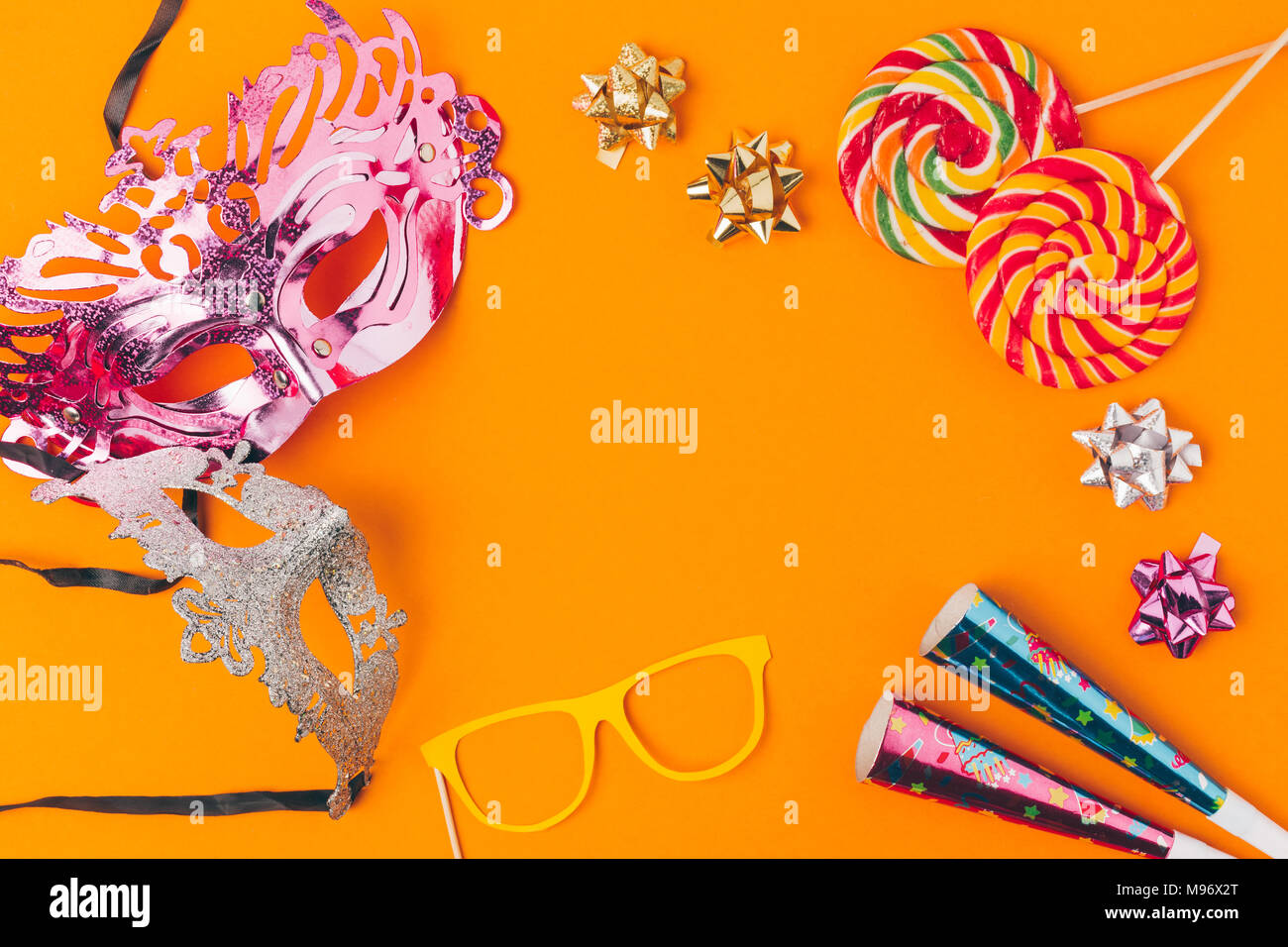 Flach mit Lutscher und Partei Objekte auf Orange, purim Urlaub Konzept isoliert Stockfoto