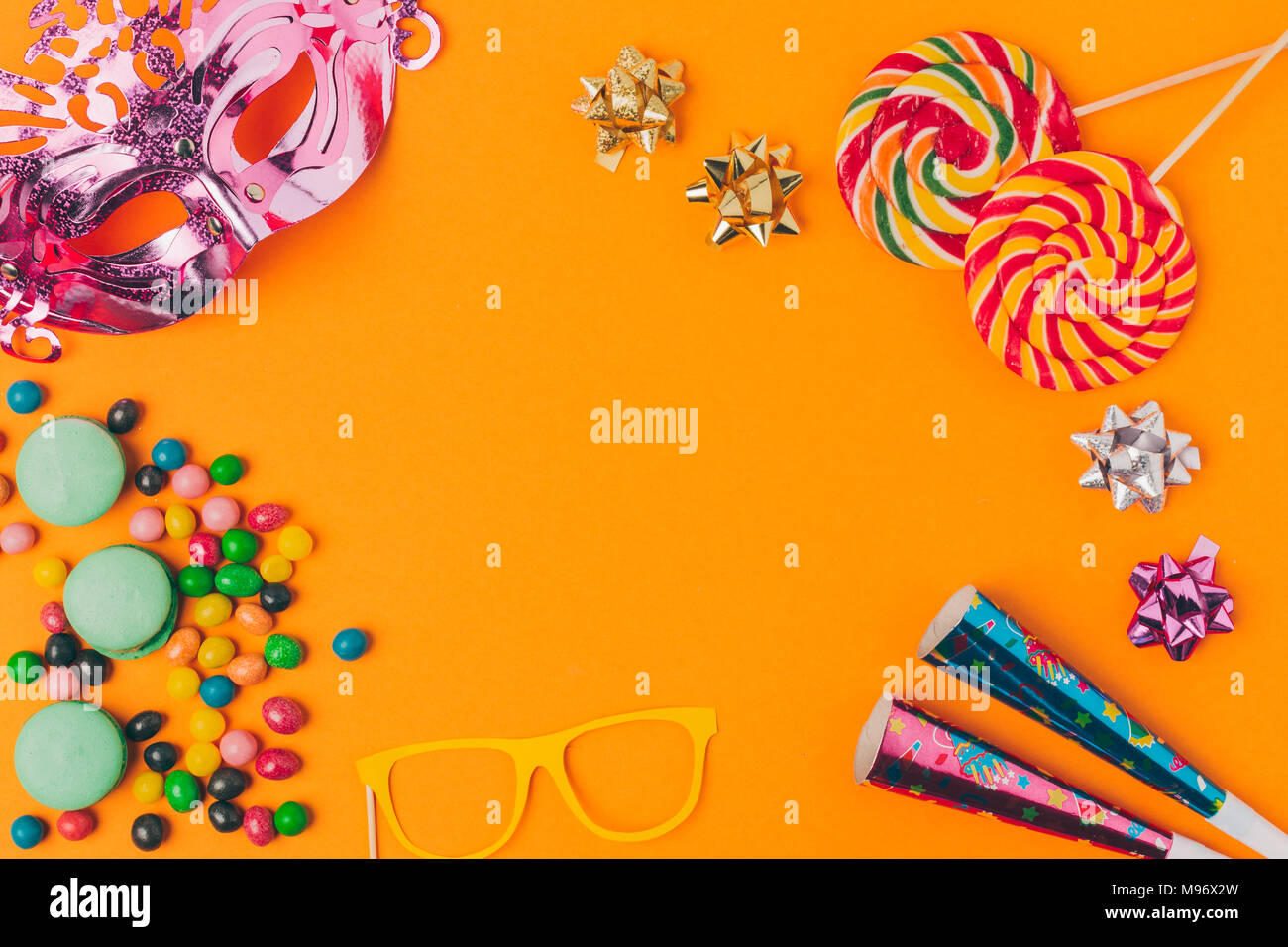Flach mit Süßigkeiten und und Party Objekte auf Orange, purim Urlaub Konzept isoliert Stockfoto