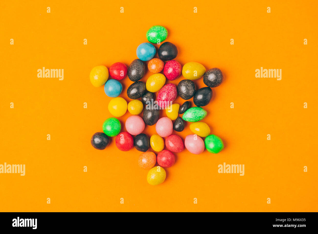 Blick von oben auf die Stern aus Süßigkeiten auf Orange, purim Urlaub Konzept isoliert Stockfoto