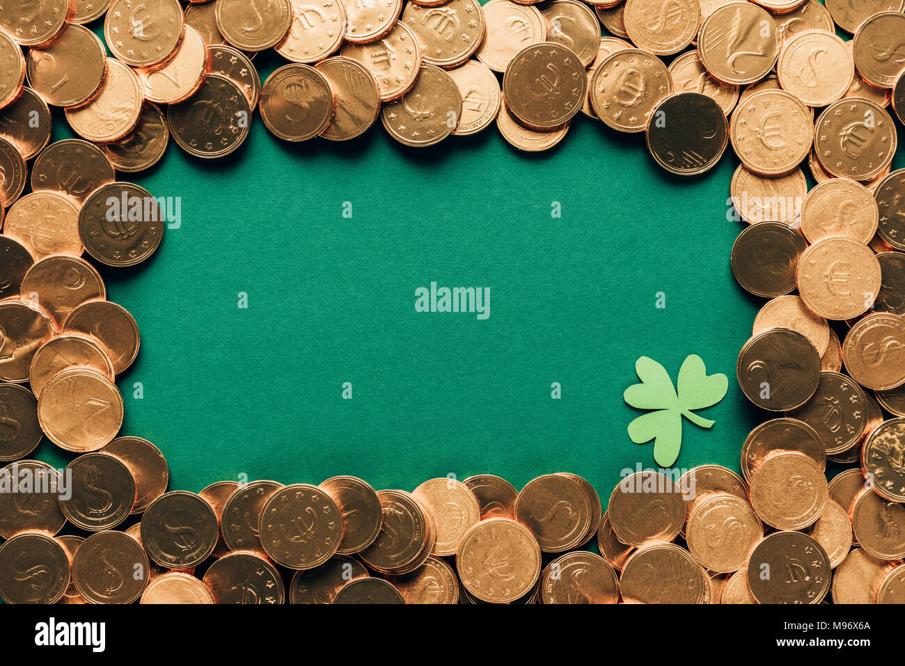 Blick von oben auf die goldenen Münzen und Shamrock am grünen Tisch, st patricks day Konzept Stockfoto