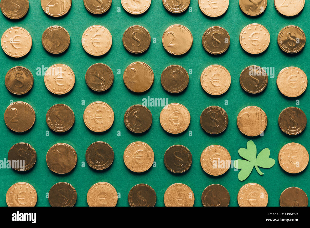 Blick von oben auf die Muster der goldenen Münzen und Shamrock auf Grün, st patricks day Konzept Stockfoto