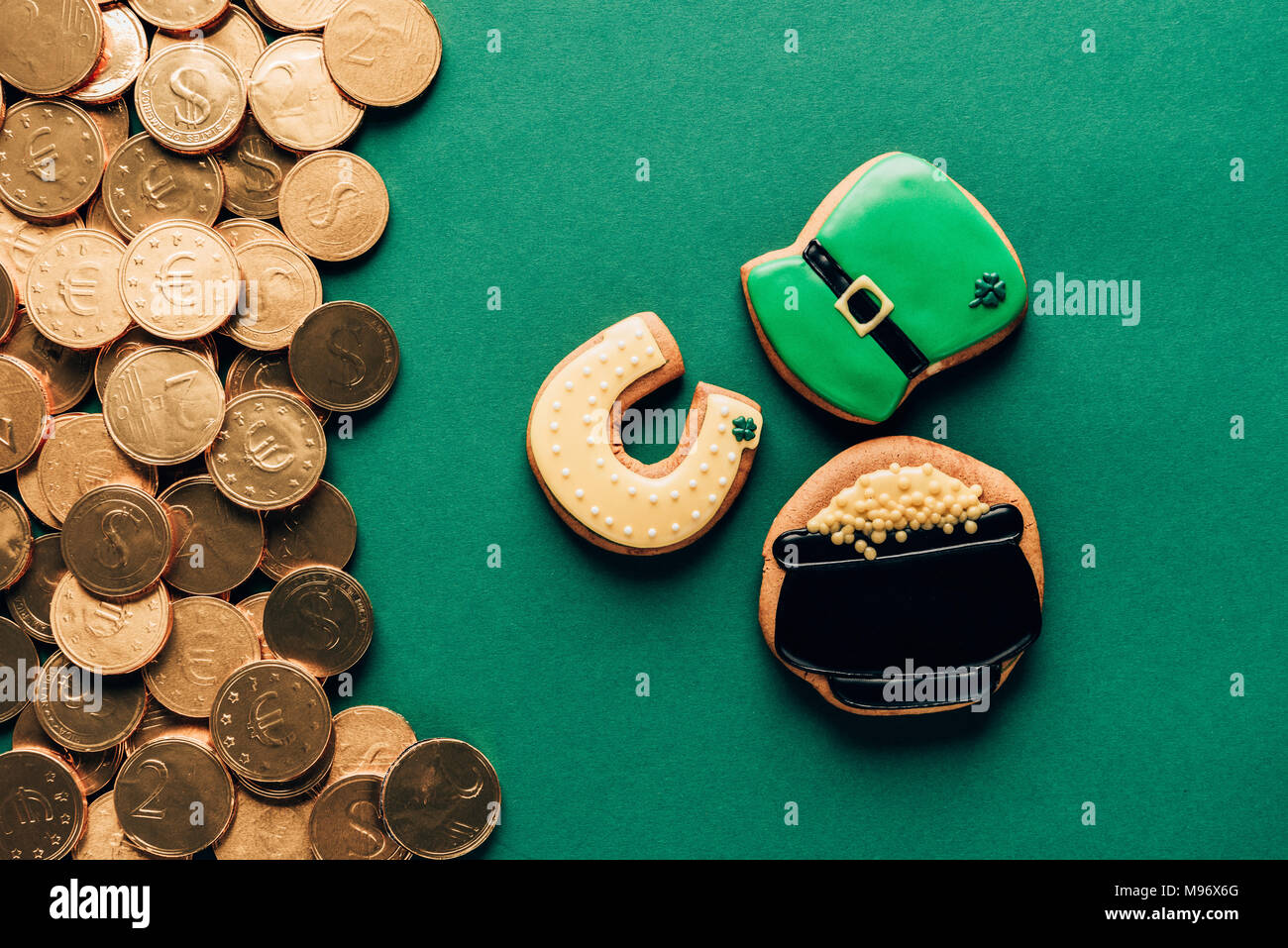 Blick von oben auf die Vereisung cookies und goldenen Münzen auf Grün, st patricks day Konzept Stockfoto
