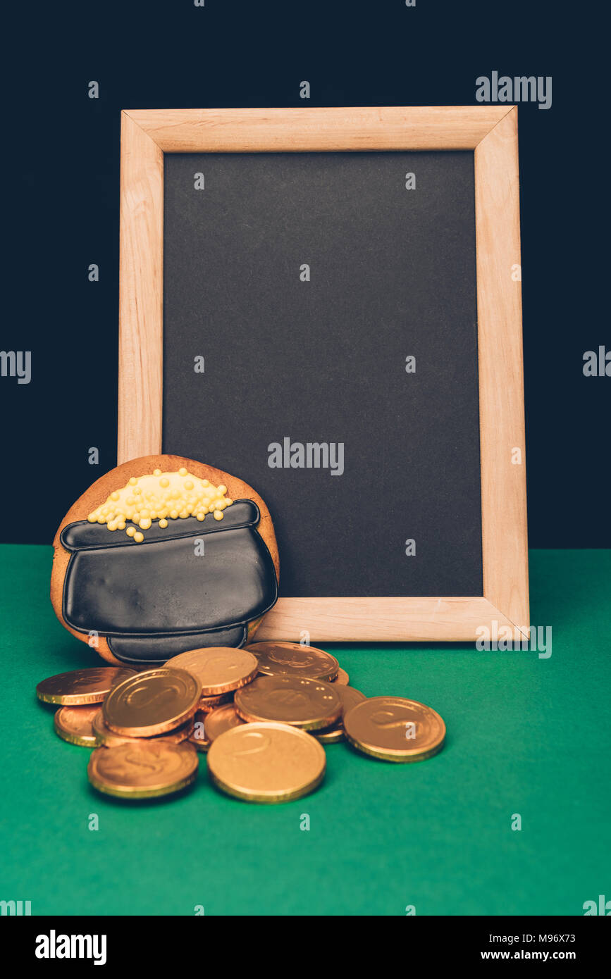 Leeren Brett mit goldenen Münzen und Lebkuchen am grünen Tisch, st patricks day Konzept Stockfoto