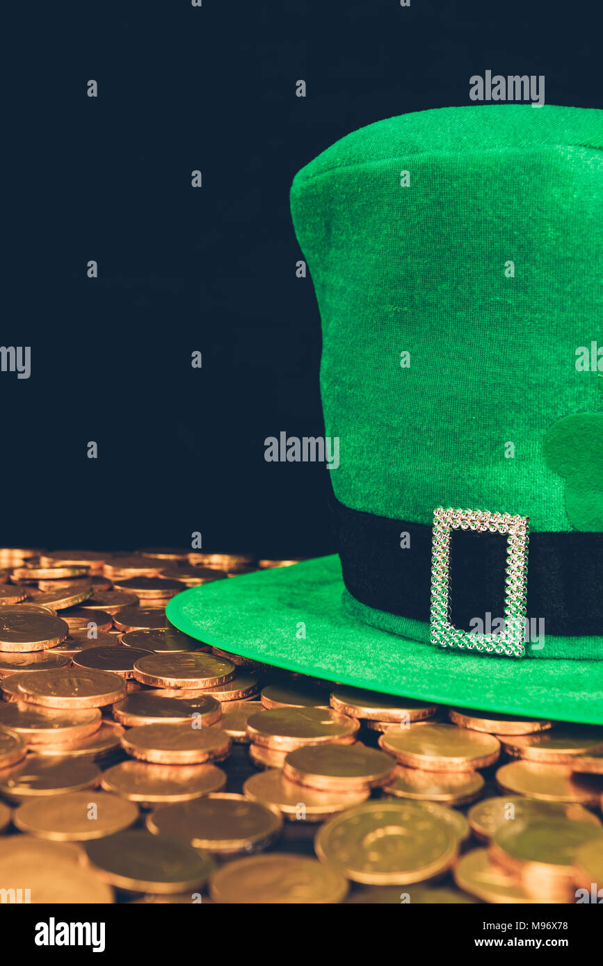 Grünen Hut auf glänzenden goldenen Münzen auf Schwarz, st patricks day Konzept isoliert Stockfoto