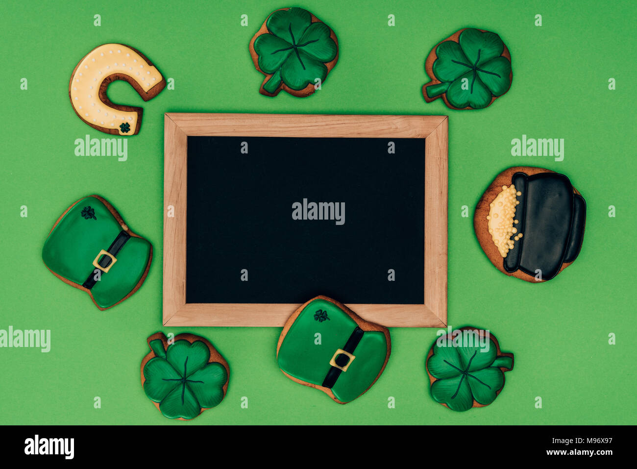 Blick von oben auf die leeren Brett mit Puderzucker Cookies auf Grün, st patricks day Konzept isoliert Stockfoto