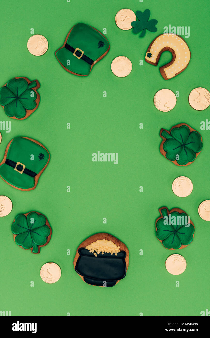 Blick von oben auf die Vereisung cookies und goldenen Münzen auf Grün, st patricks day Konzept isoliert Stockfoto