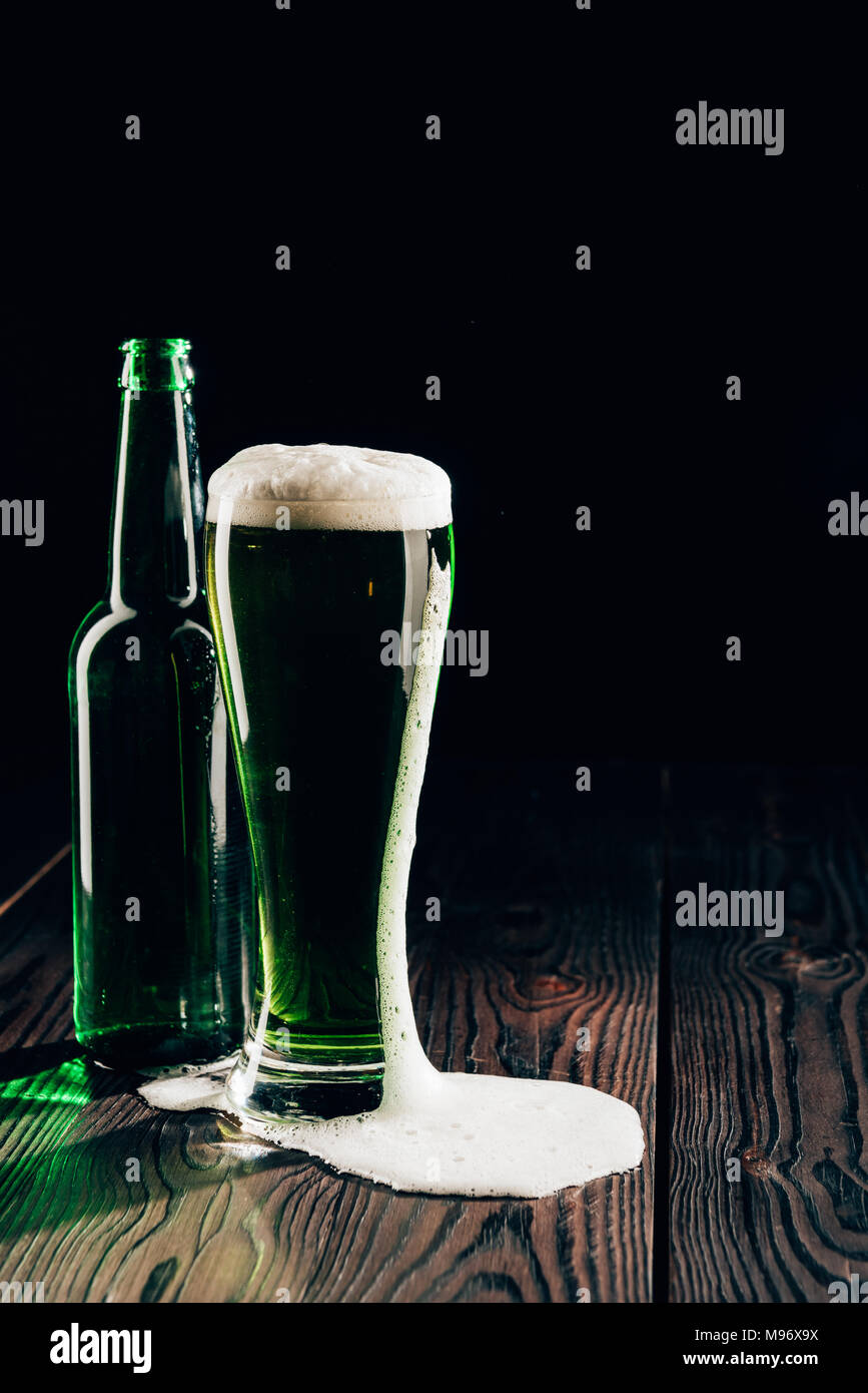Glas und Flasche grün Bier auf Holz- Oberfläche, st patricks day Konzept Stockfoto