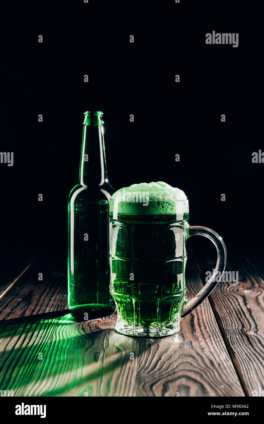 Glas und Flasche grün Bier auf hölzernen Tischplatte, st patricks day Konzept Stockfoto