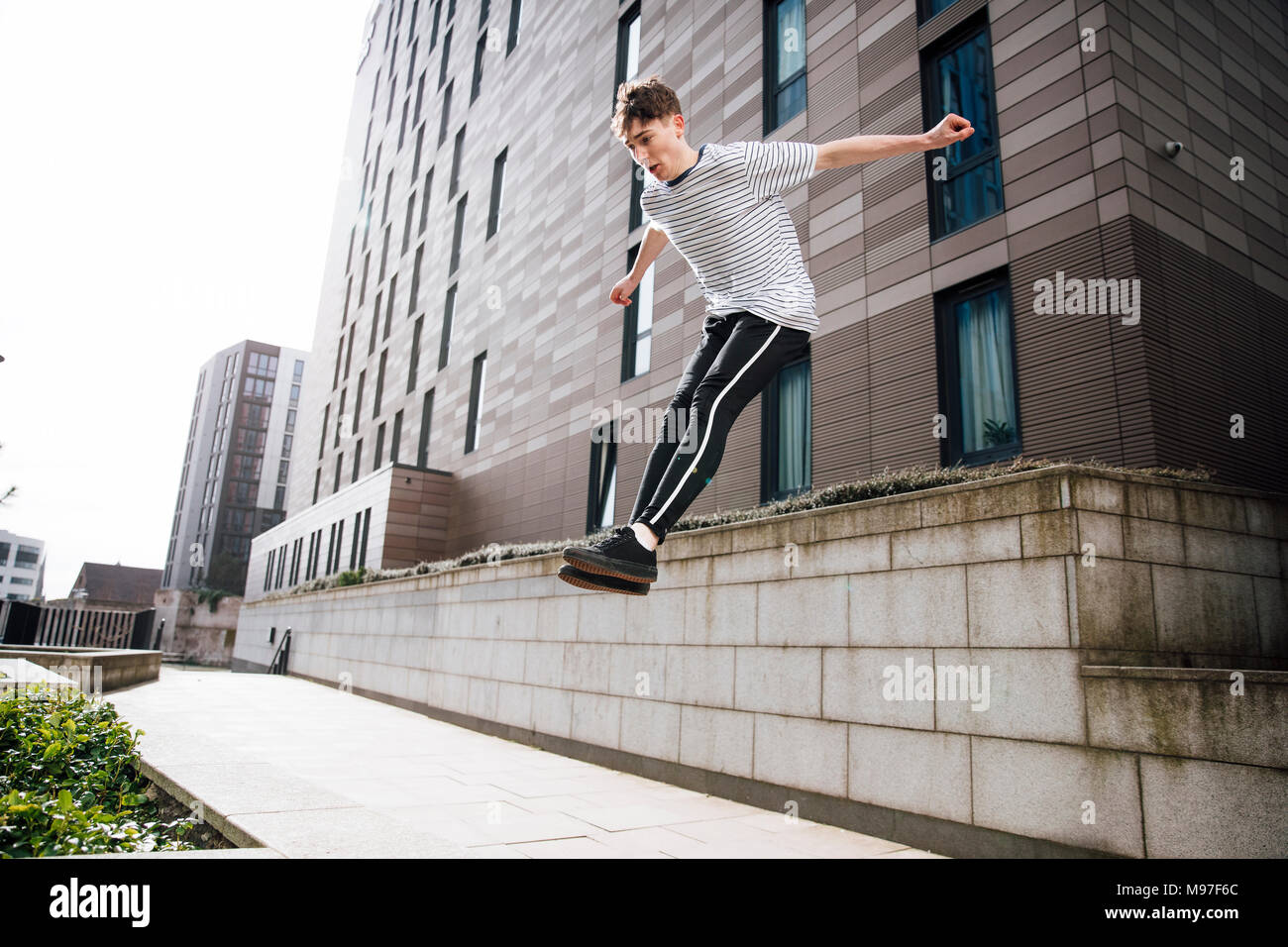 Junge freerunner ist das Springen von einer Wand in der Stadt. Stockfoto