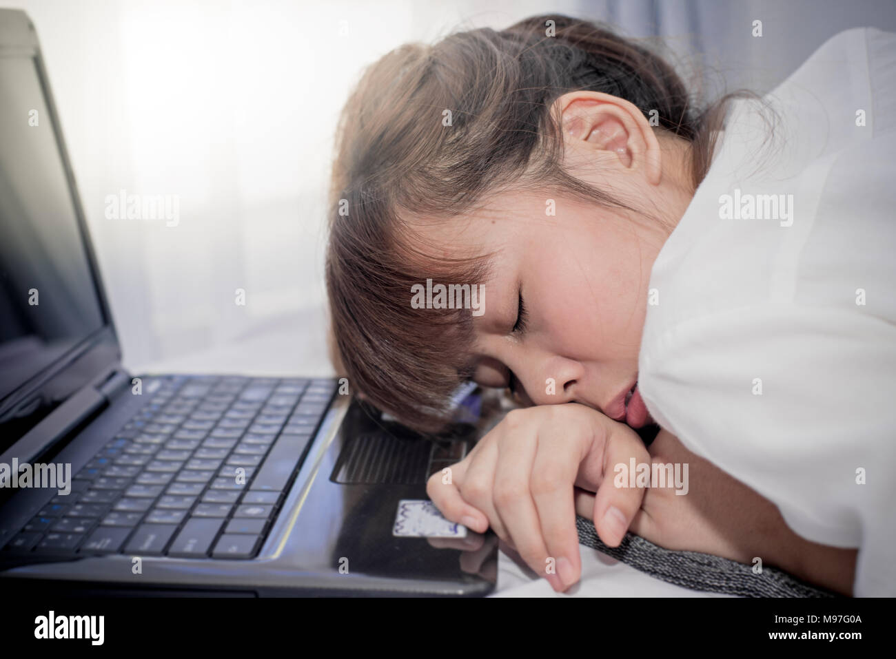 Asiatische Frau schlafen auf Ihrem Laptop Stockfoto