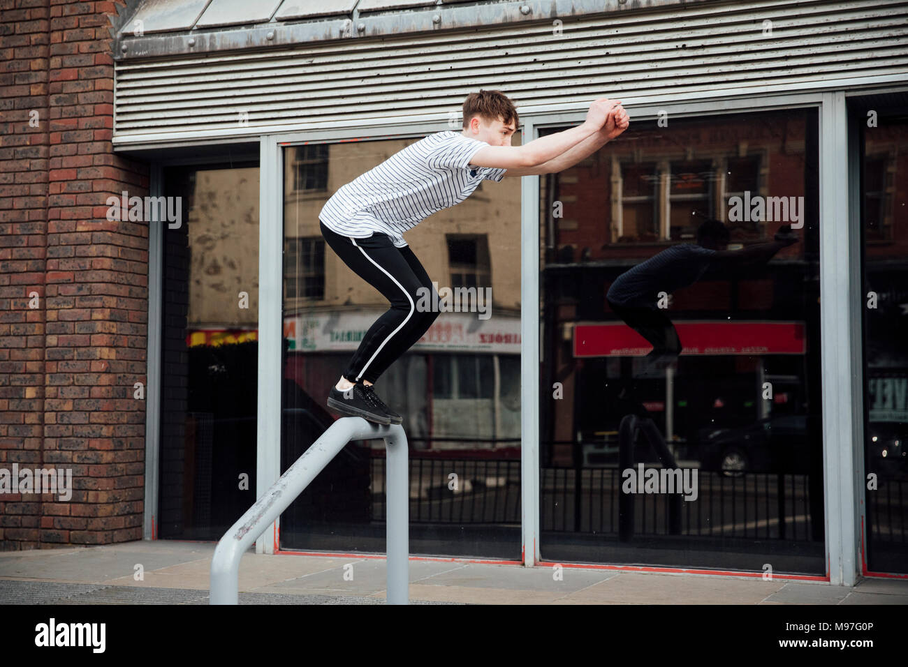 Freerunner ist das Springen zwischen den Mauern und Geländer in der Stadt. Stockfoto