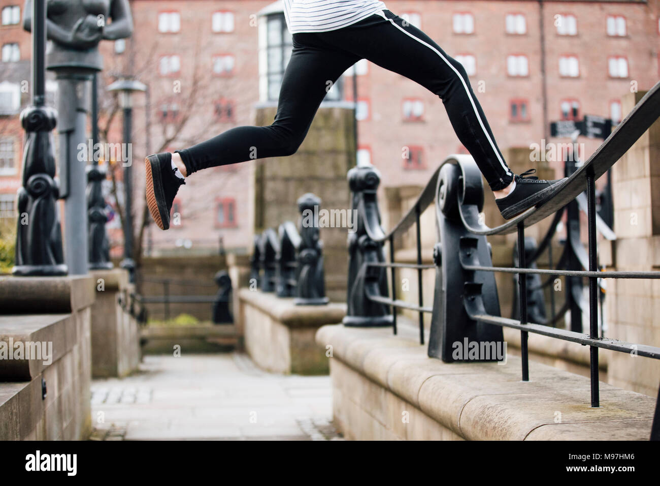 Nahaufnahme von einem freerunners Beine, wie er springt zwischen Geländer und Wände in der Stadt. Stockfoto