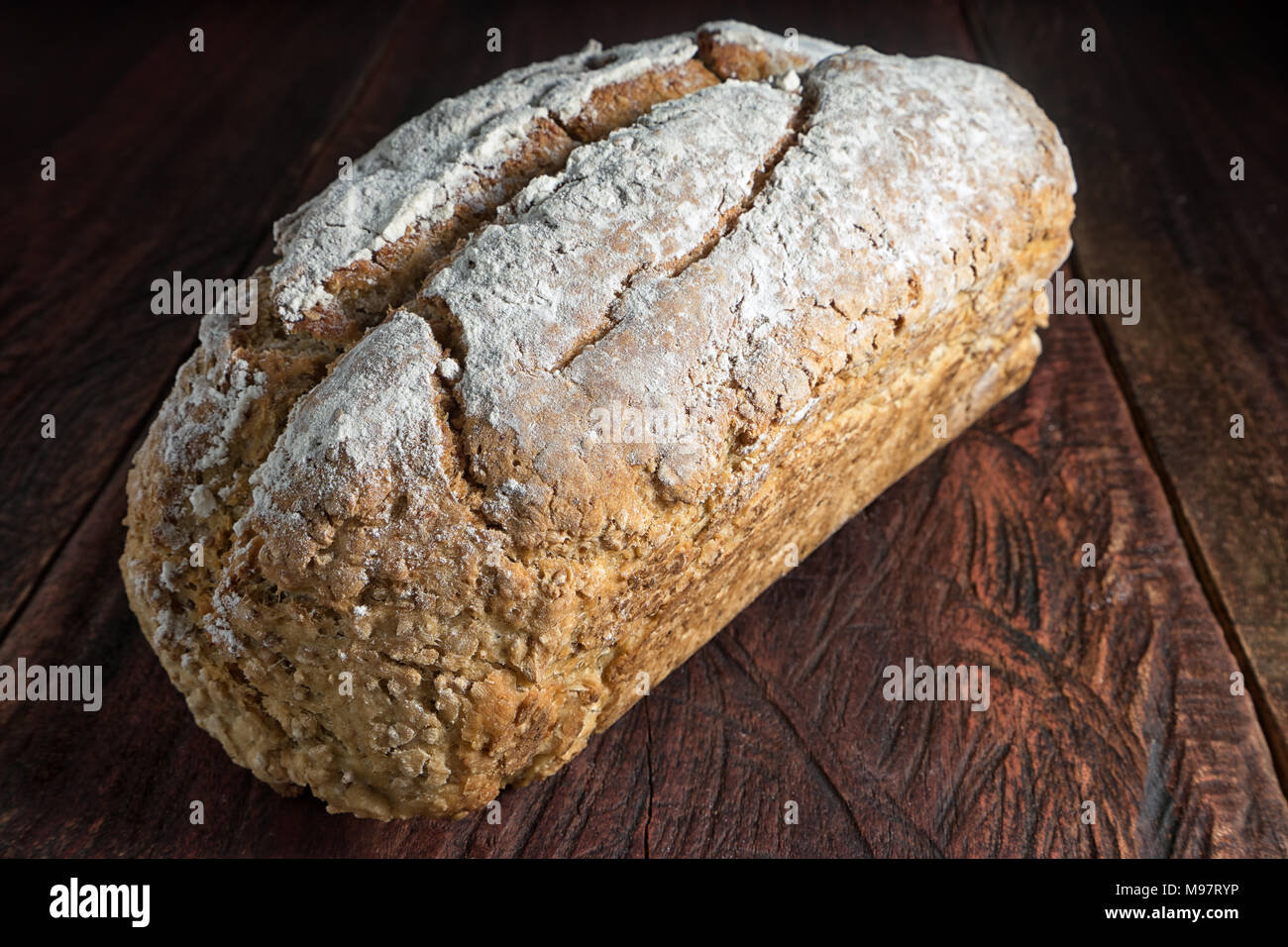 Laib Artisan Brot auf rustikalen Holzmöbeln Hintergrund Stockfoto