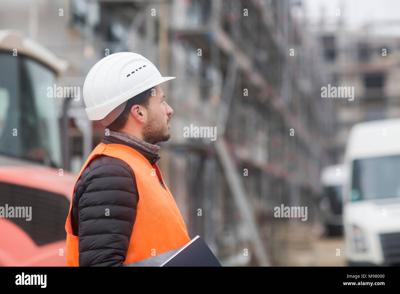 Mann mit Warnweste und Helm auf der Baustelle Stockfoto