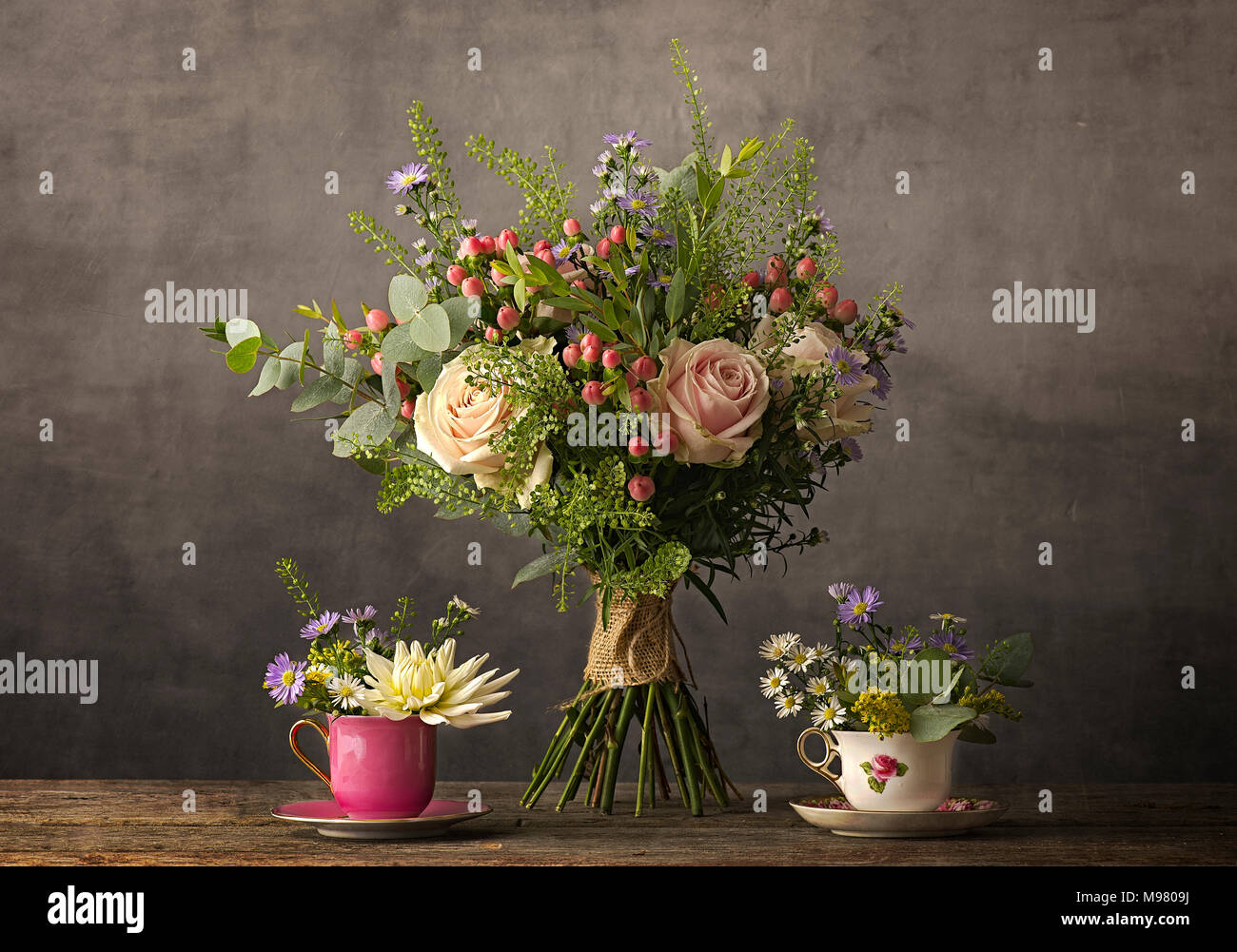 Blumenstrauß aus Rosen und Blumen in Tasse Tee Stockfoto