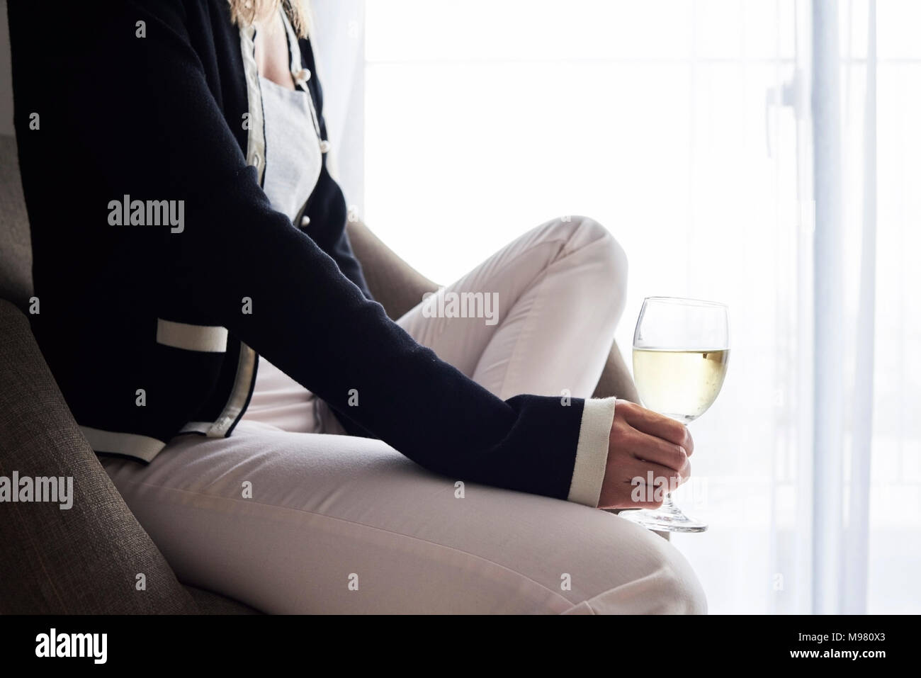 Frau mit einem Glas Wein zu Hause dunkles bequem. Stockfoto