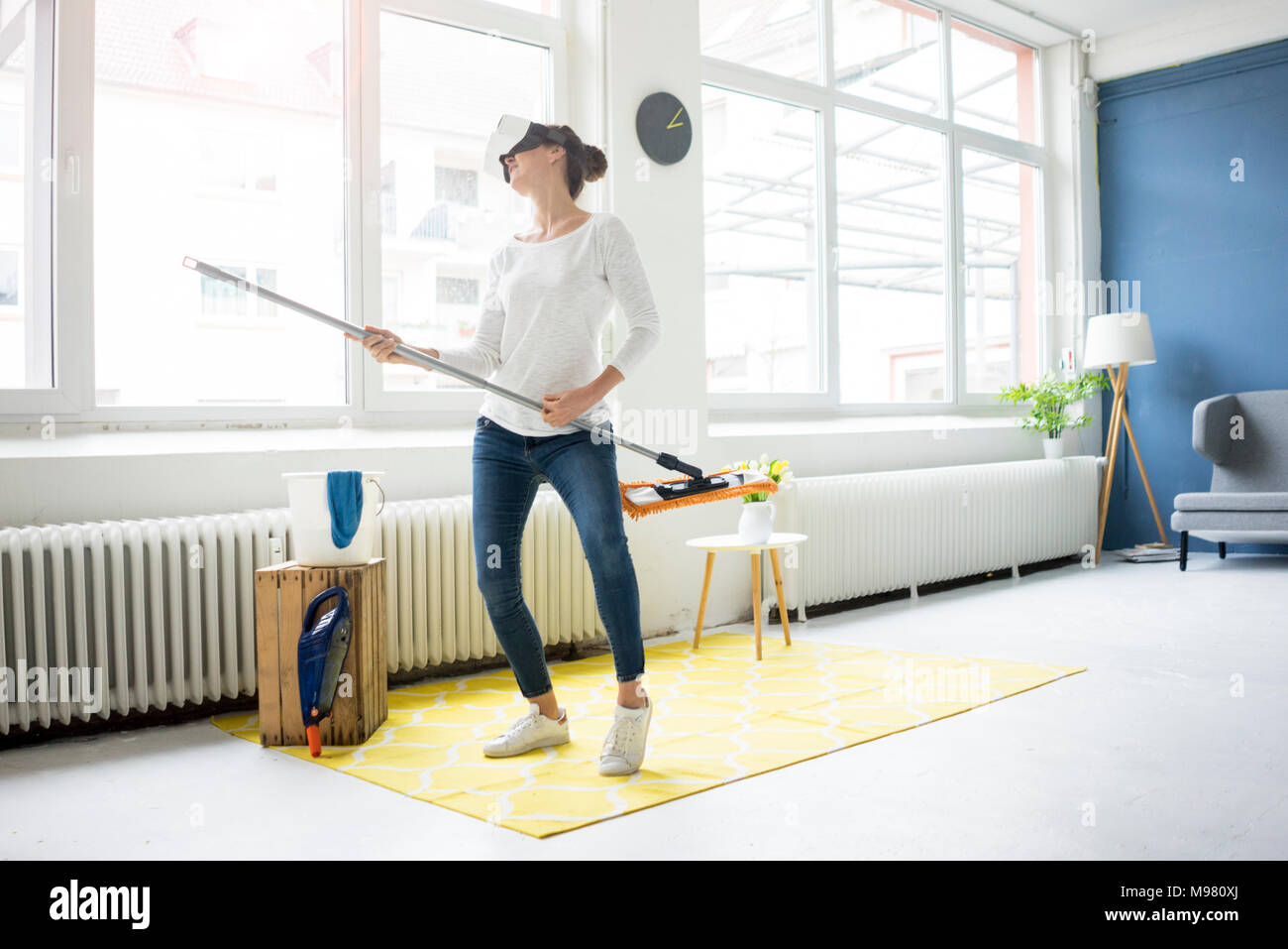Vital Frau zu Hause tragen VR-Brille wischen den Boden Stockfoto