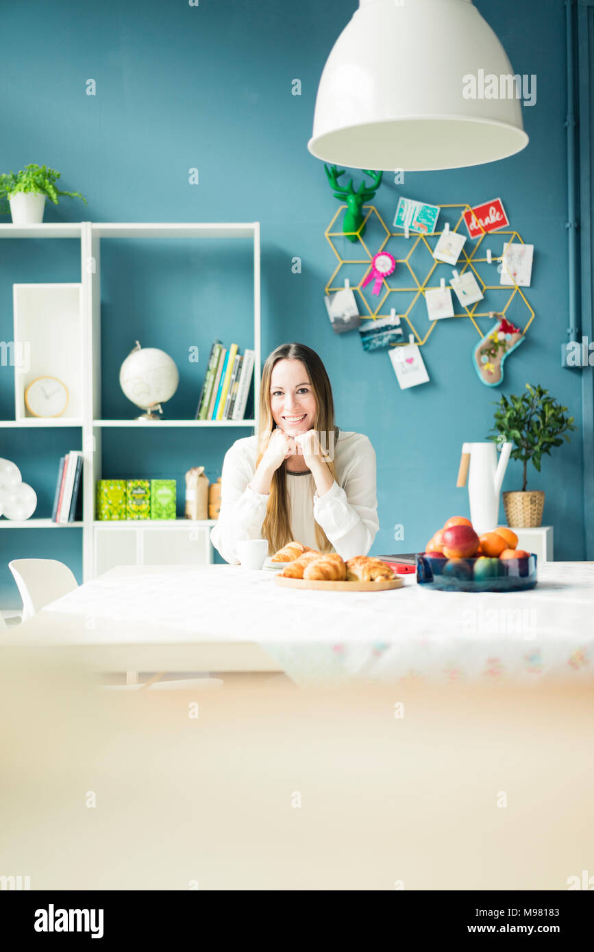 Portrait von lächelnden Frau am Frühstückstisch sitzen Stockfoto