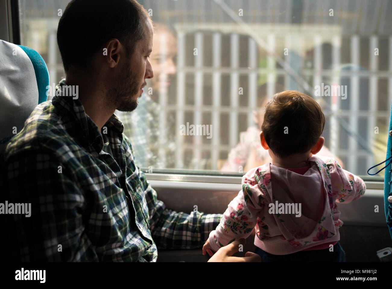 Vater und Baby Mädchen, die mit dem Zug anreisen, aus Fenster Stockfoto