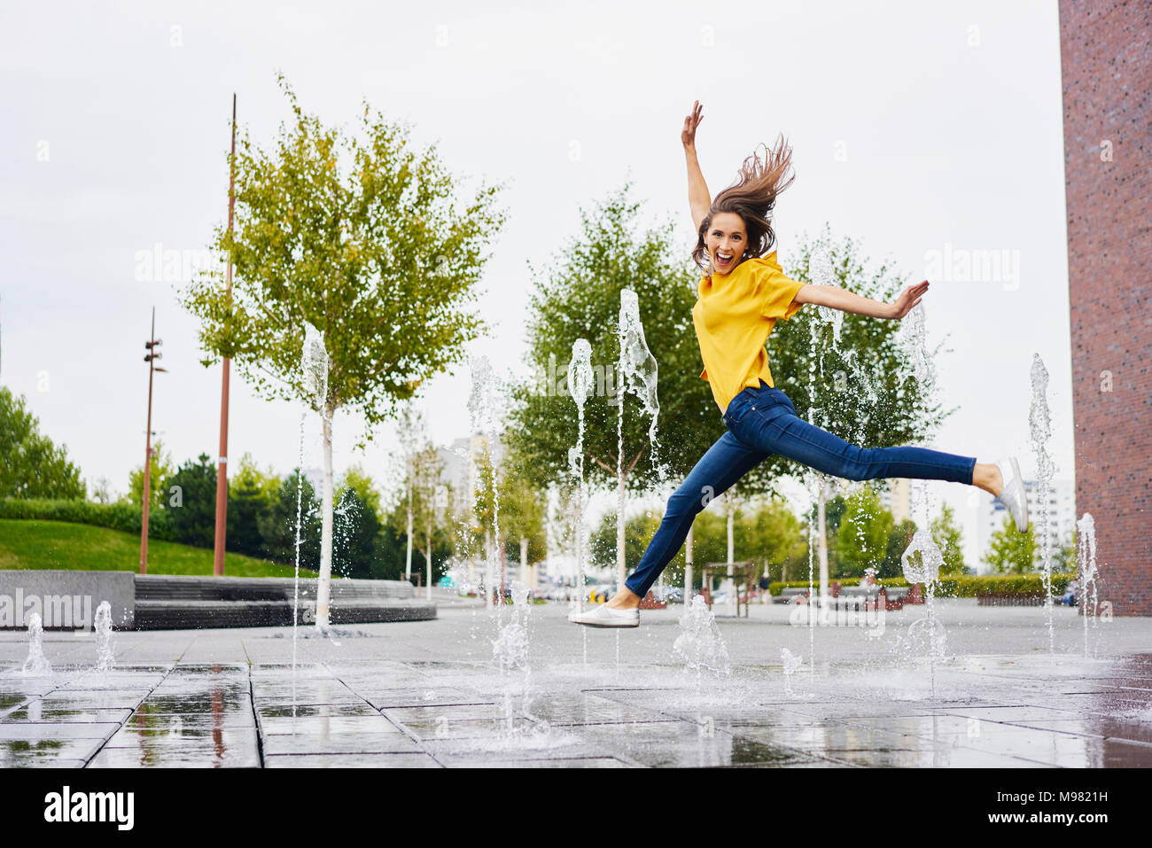 Glückliche junge Frau in die Luft springen Stockfoto