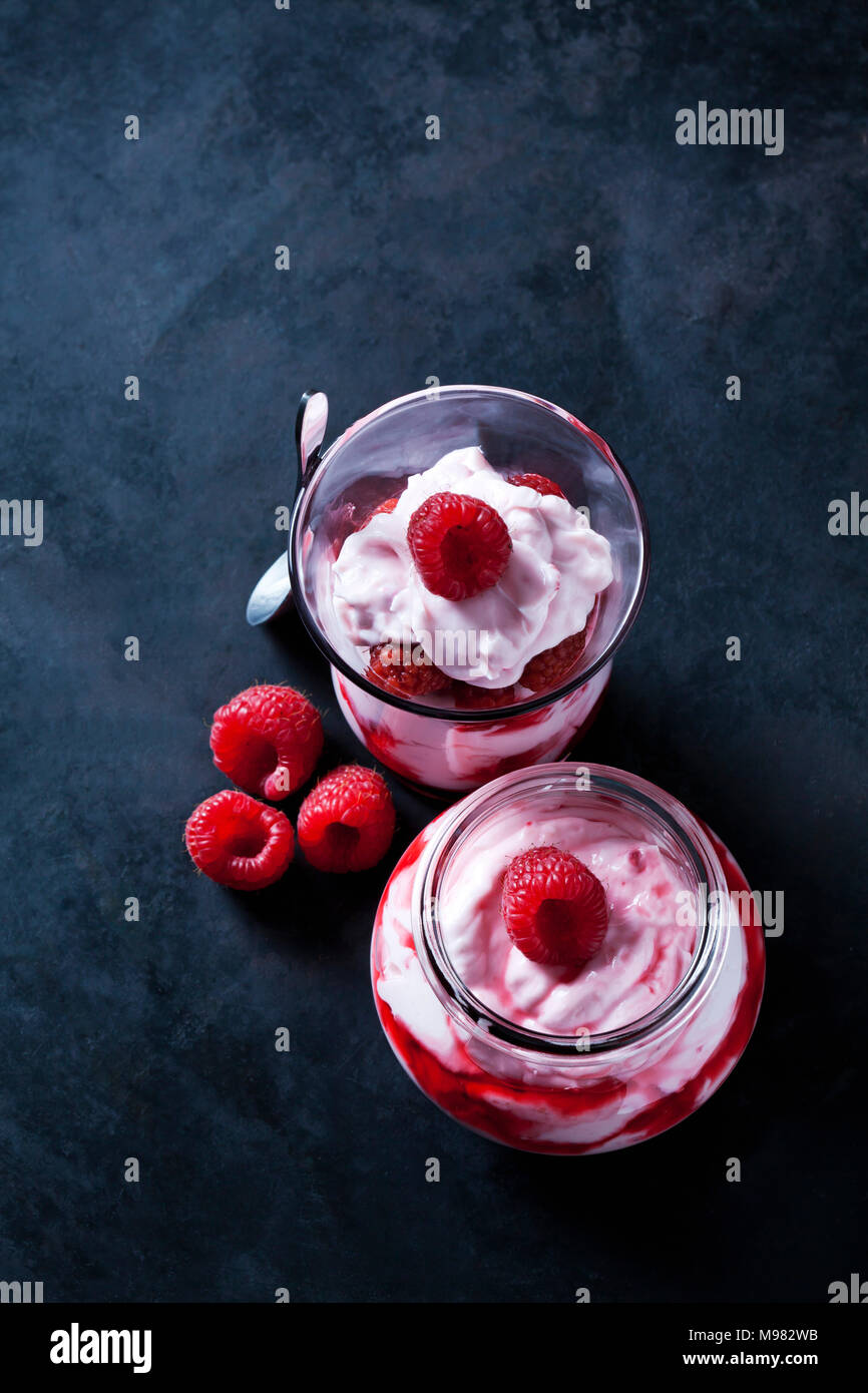 Kleinigkeit von Schlagsahne mit Erdbeeren und Erdbeersauce in Gläsern Stockfoto