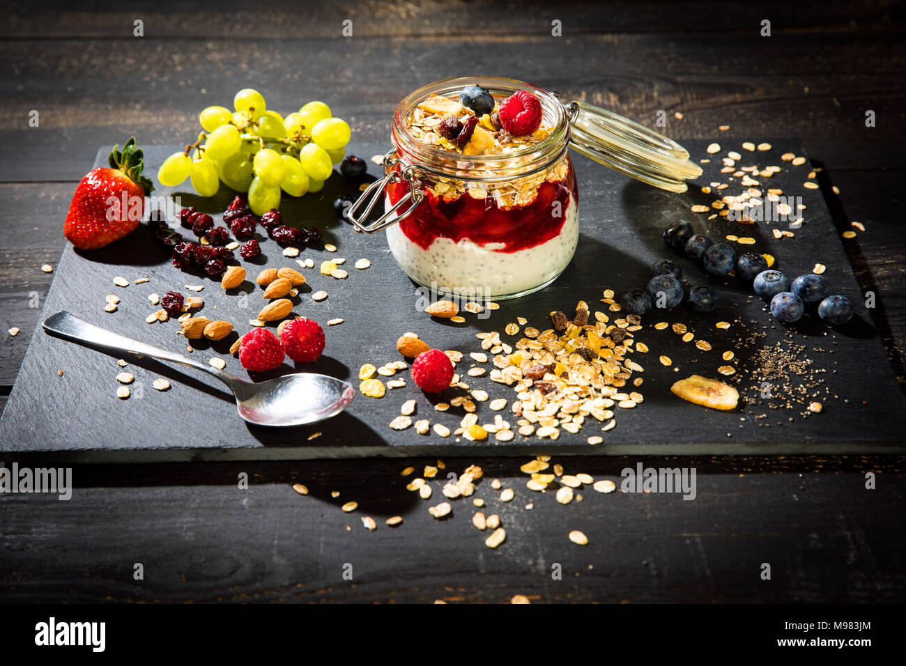 Müsli mit Rote Grütze, Chia, Quark, Himbeere, Mandel, Moosbeere, Blue Berry, getrocknete Bananen, Trauben Stockfoto