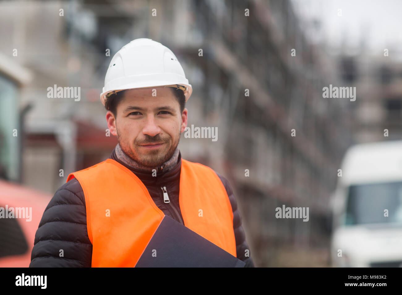 Portrait von Inhalt mann mit warnweste und Helm auf der Baustelle Stockfoto