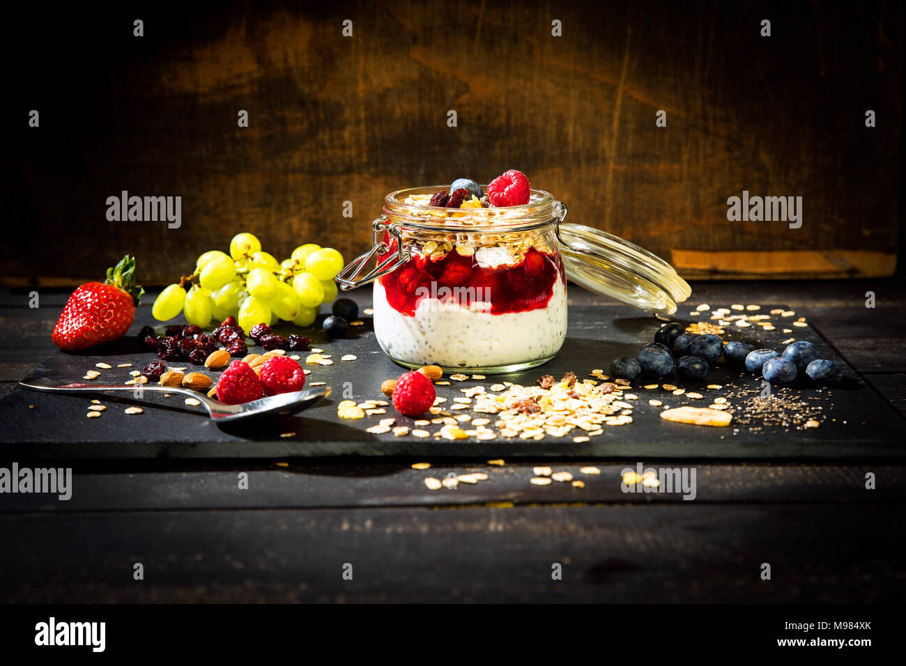 Müsli mit Rote Grütze, Chia, Quark, Himbeere, Mandel, Moosbeere, Blue Berry, getrocknete Bananen, Trauben Stockfoto