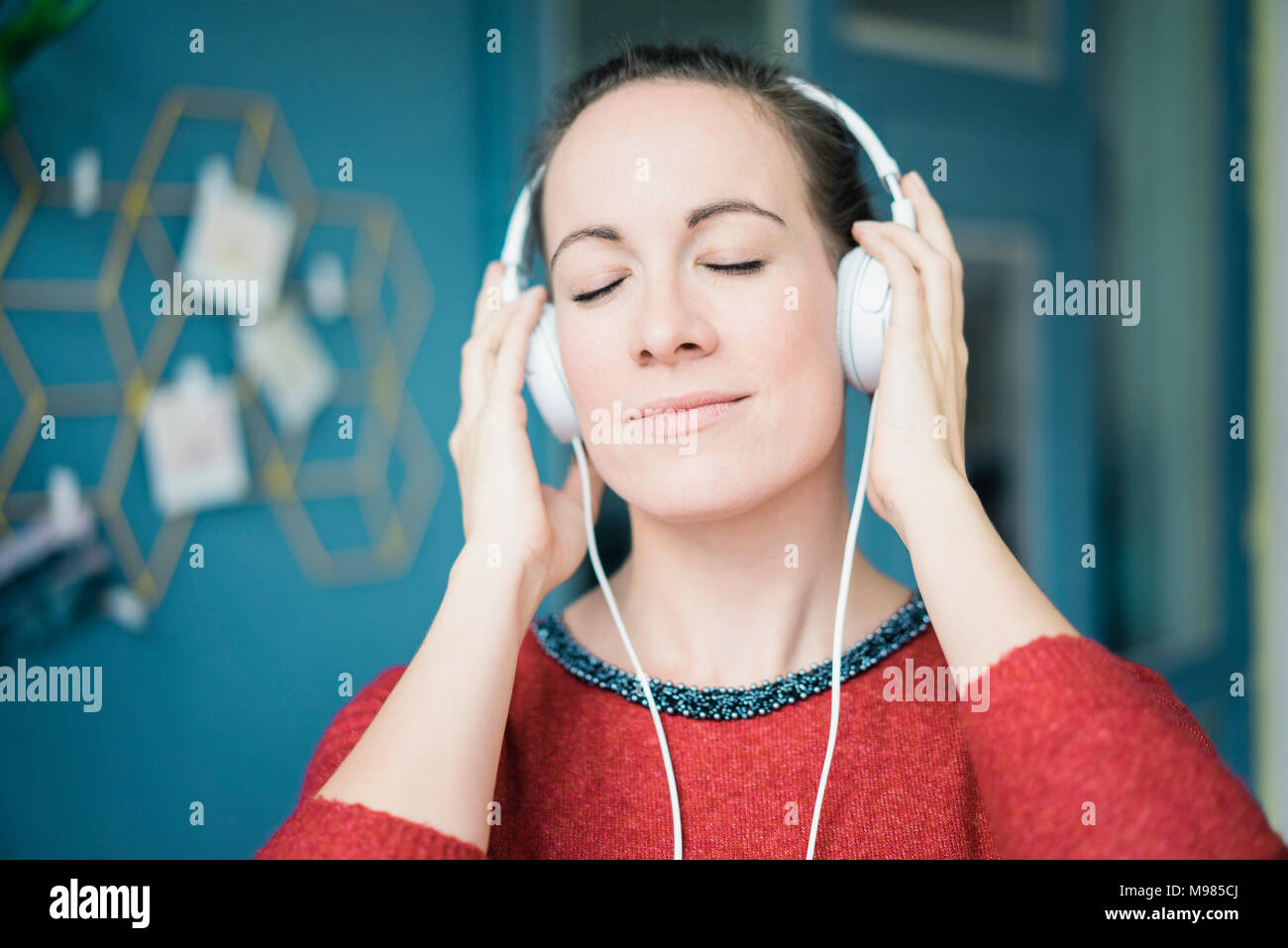 Portrait von Frau mit geschlossenen Augen hören Musik über Kopfhörer Stockfoto