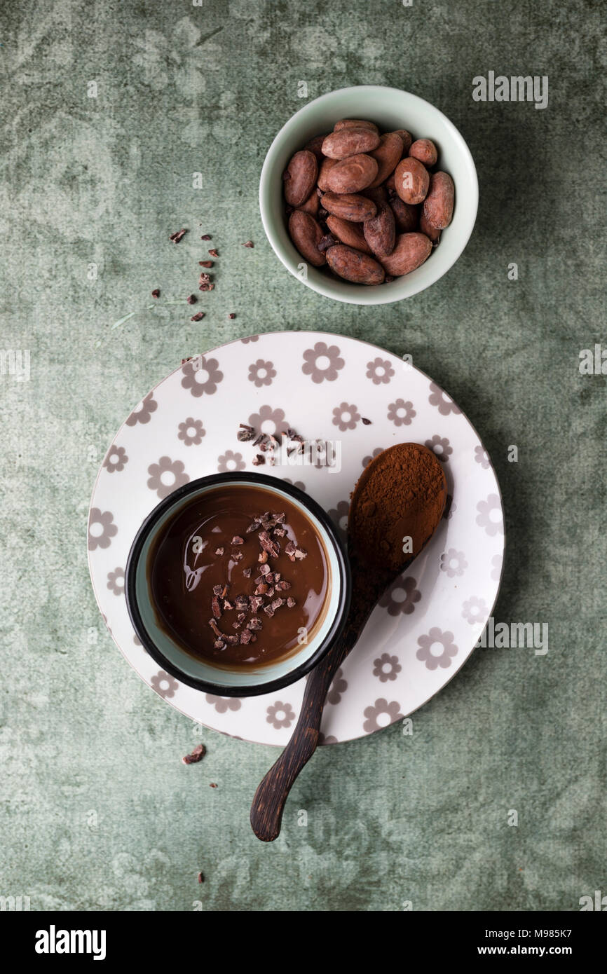 Tasse Schokoladenpudding mit Kakao, Kakao Nibs und Kakaobohnen Stockfoto