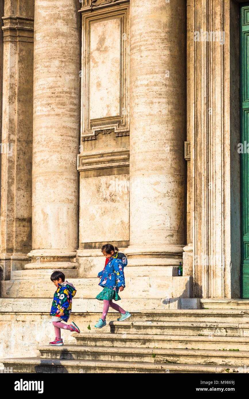 Zwei chinesische Kinder auf den Stufen der Kirche Santi Luca e Martina neben dem Forum Romanum, Rom, Latium, Italien. Stockfoto