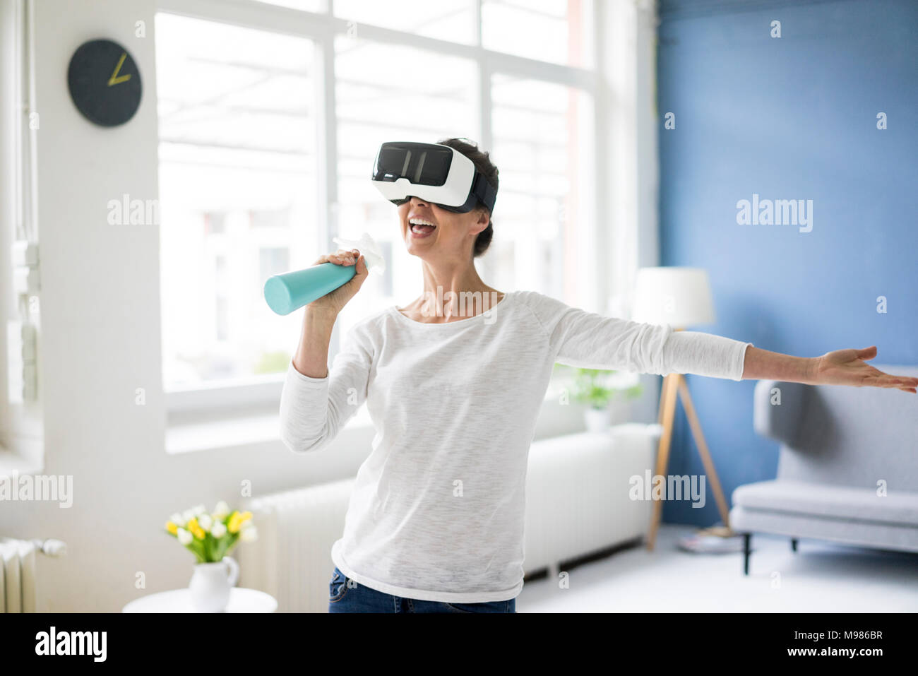 Vital Frau zu Hause Reinigung tragen VR-Brille Stockfoto