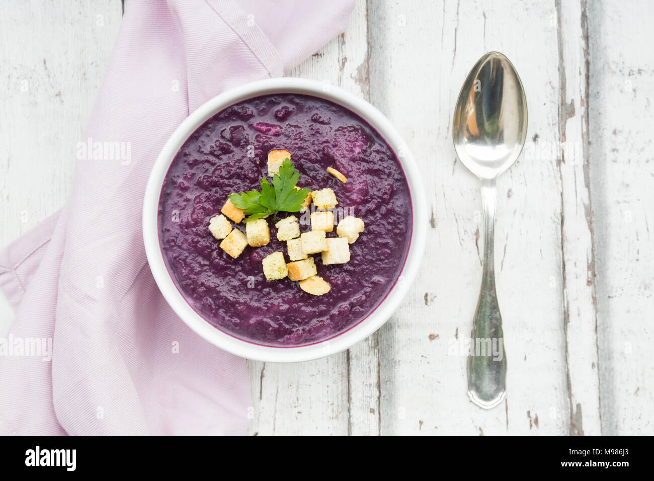 Schüssel mit Rotkohl Suppe mit Croutons und Blatt Petersilie garniert Stockfoto
