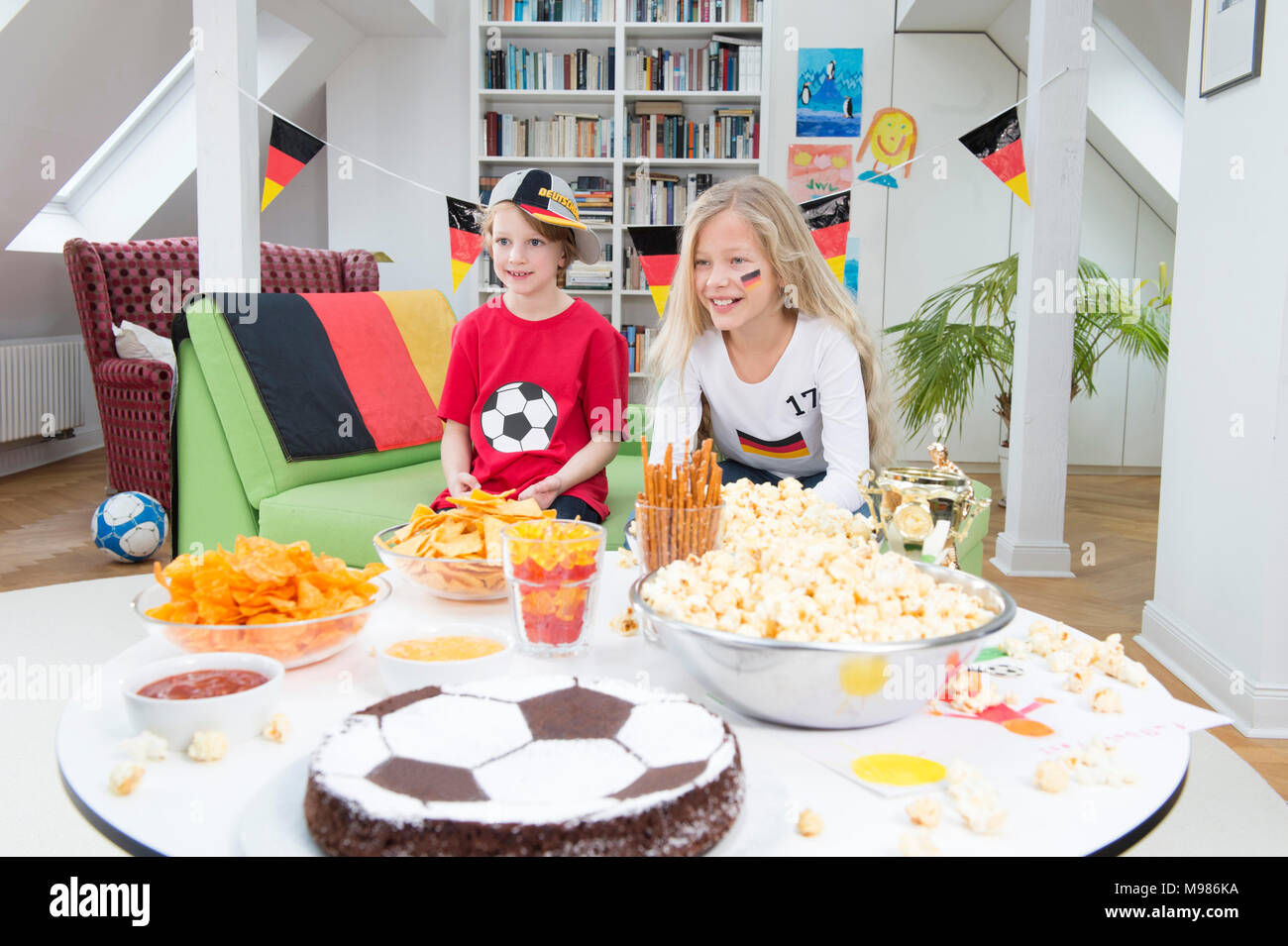 Bruder und Schwester, Fußball-Weltmeisterschaft mit Süßigkeiten und Snacks Stockfoto