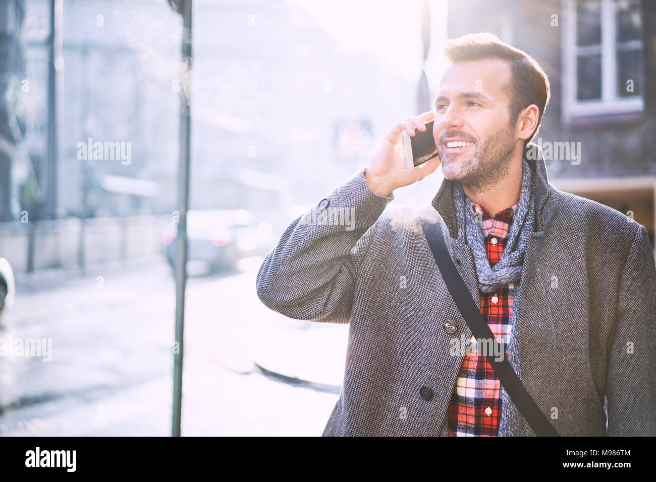 Portrait von lächelnden Mann am Telefon im Winter Stockfoto