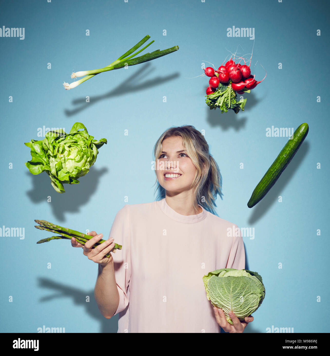 Portrait von glücklichen jungen Frau jonglieren mit Gemüse Stockfoto