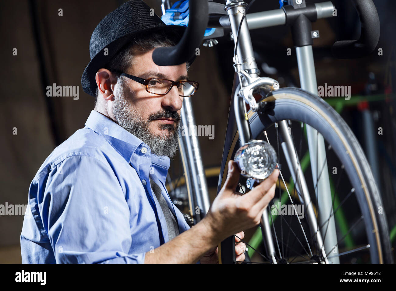 Mann bei der Arbeit auf dem Fahrrad in der Werkstatt Stockfoto