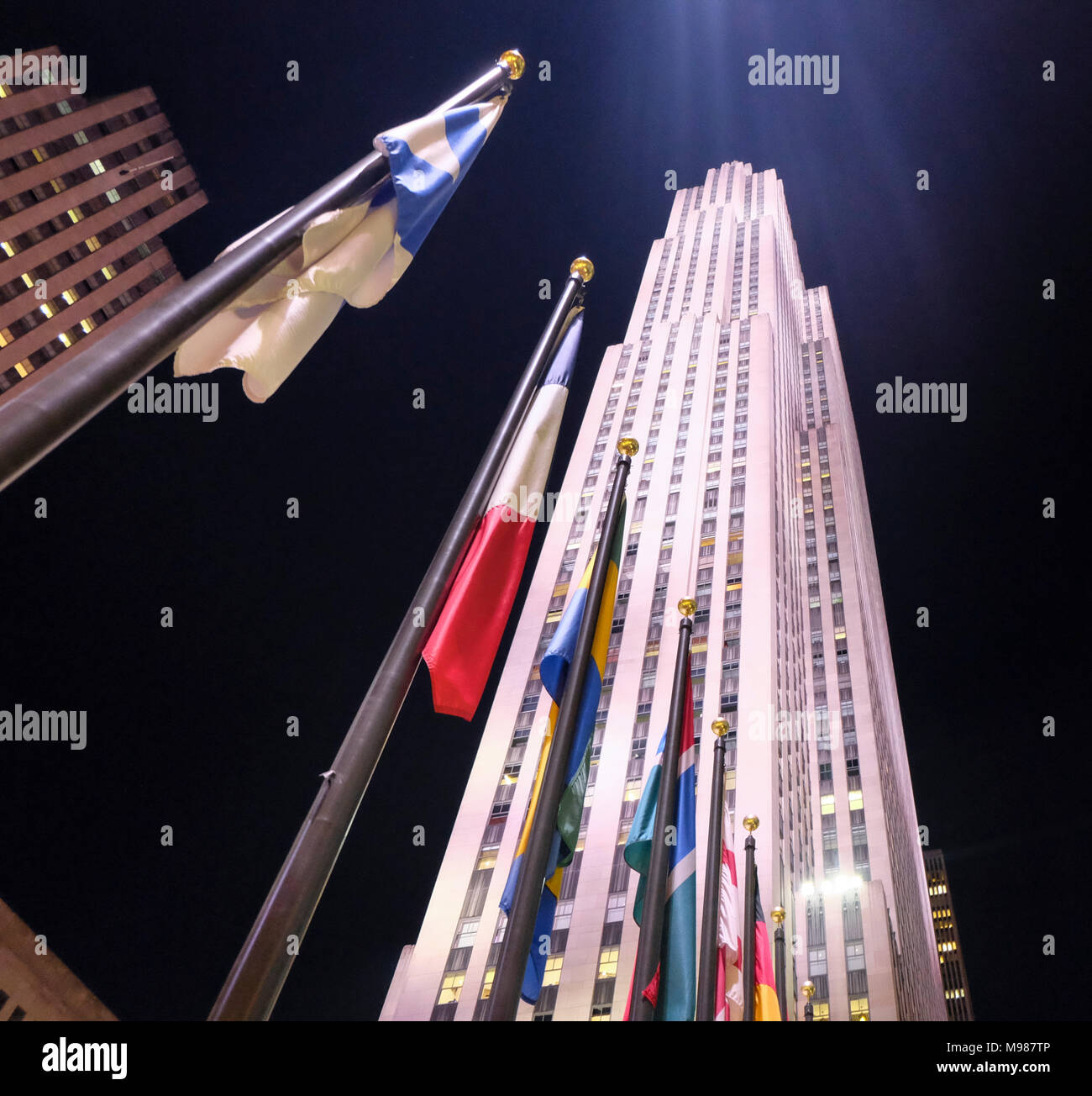 USA, New York City, internationale Flaggen vor dem Rockefeller Center bei Nacht Stockfoto