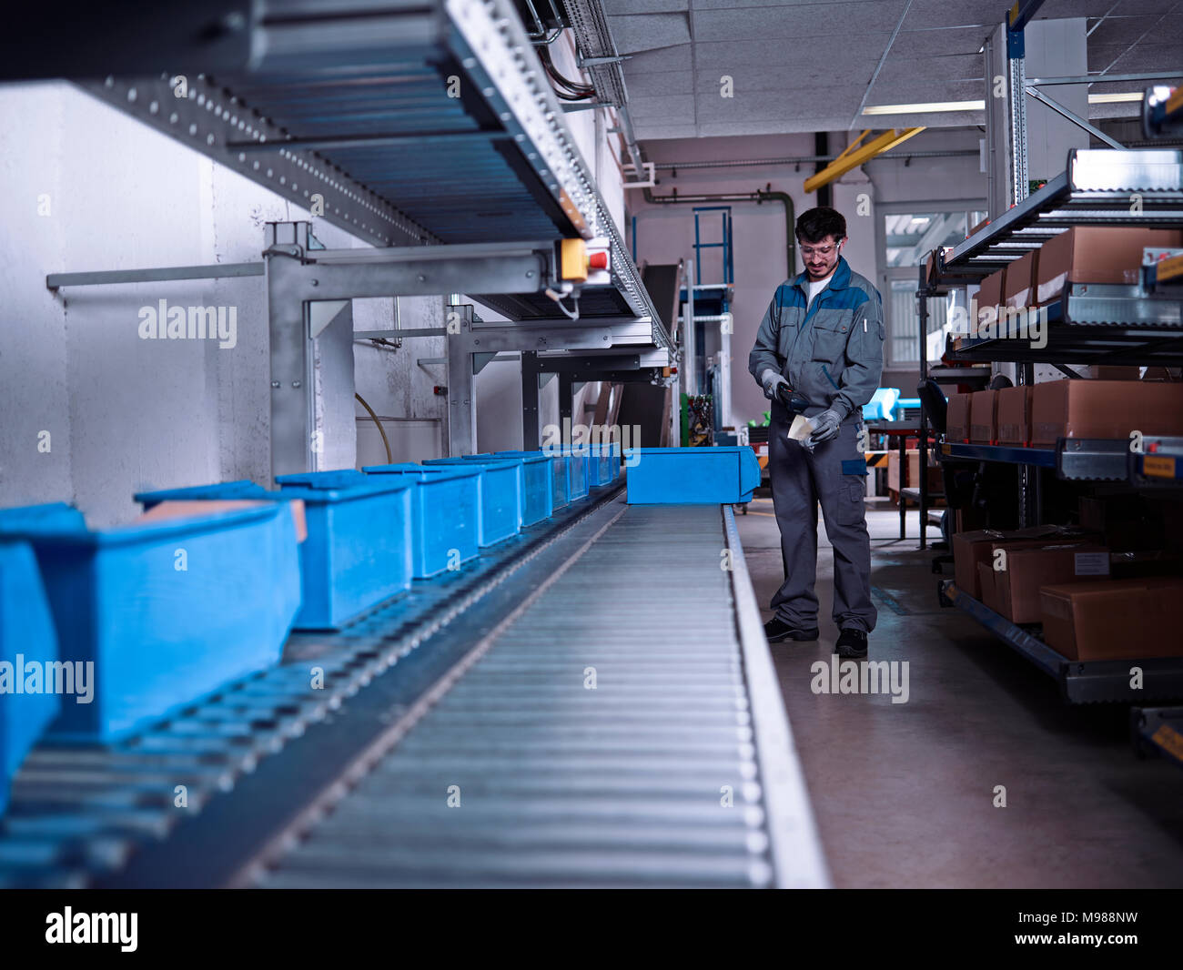 Arbeiter scannen Merchandise am Transportband Stockfoto