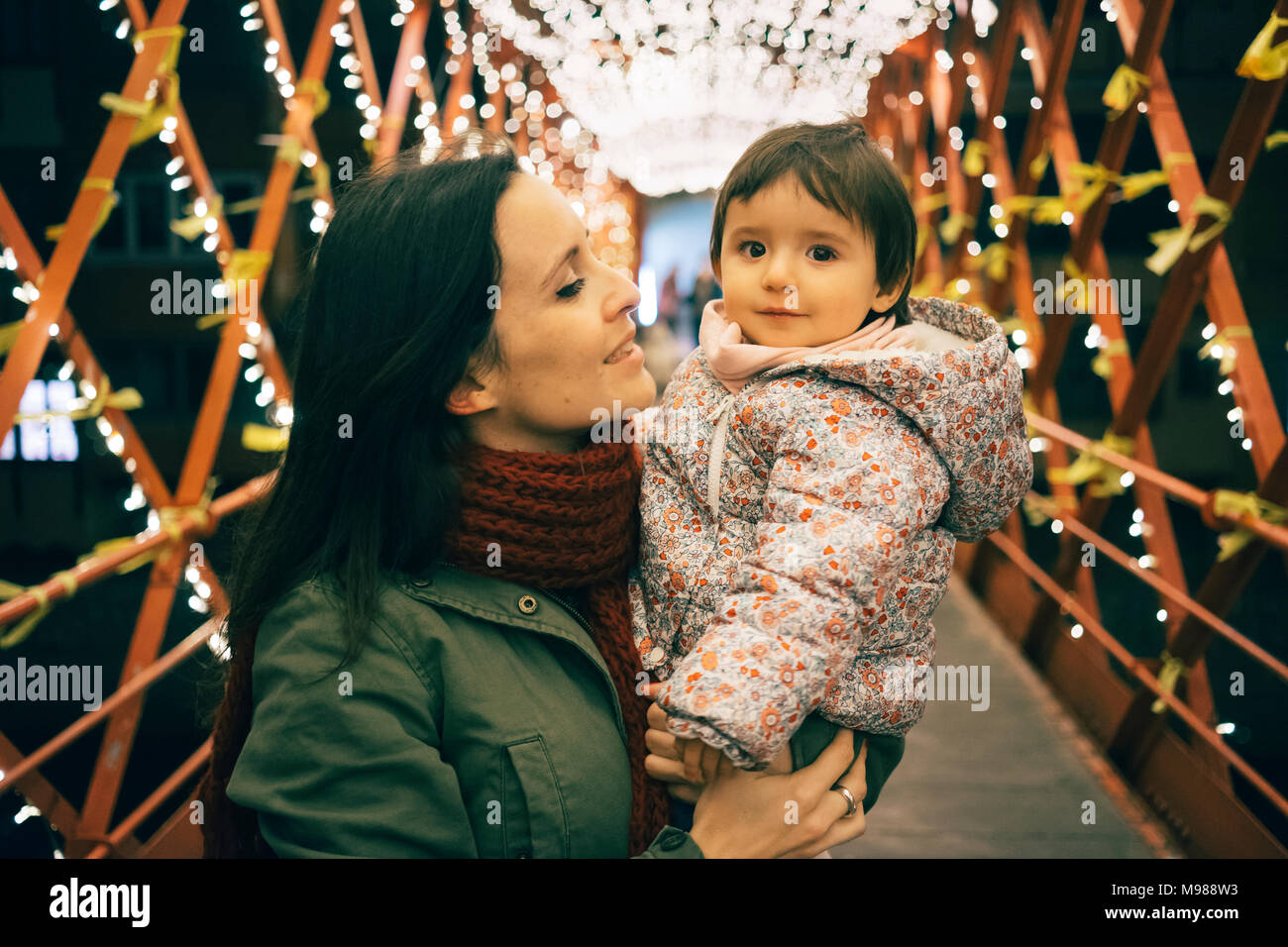 Mutter und Baby Mädchen auf der Brücke mit Beleuchtung zu Weihnachten Stockfoto