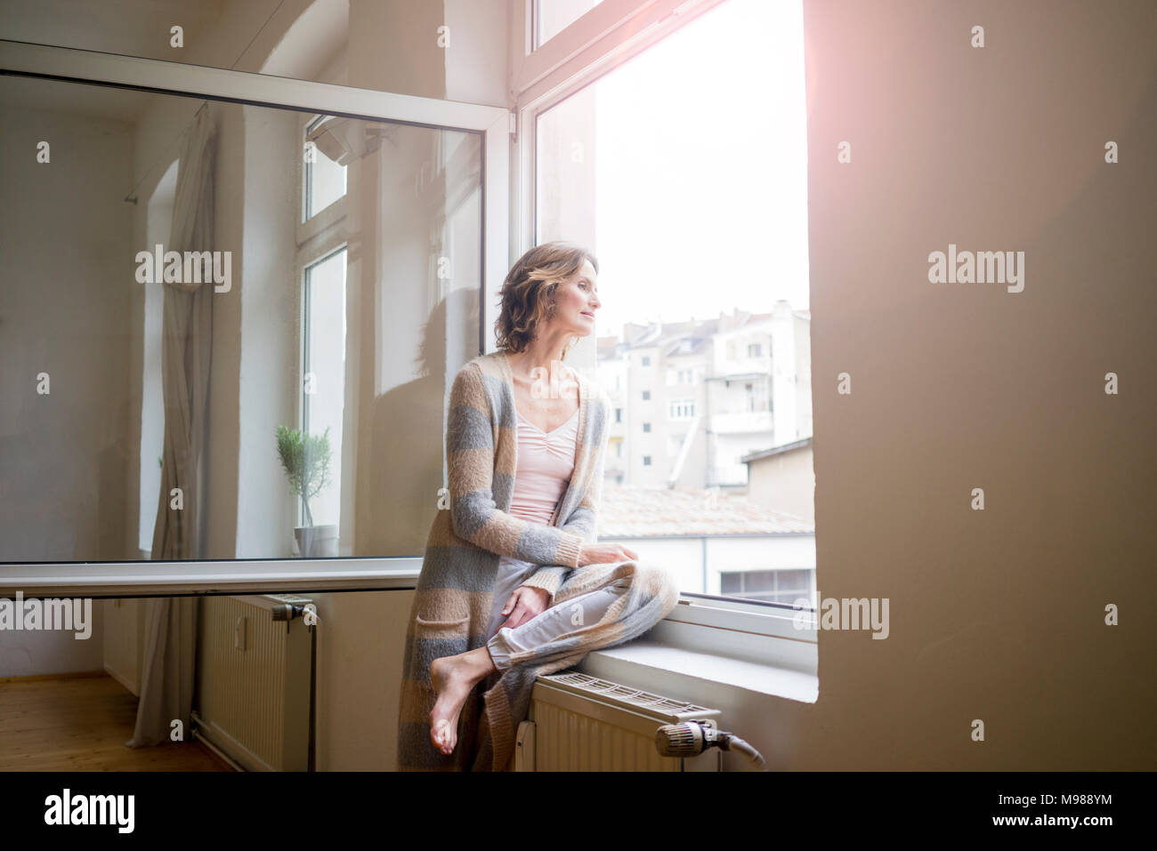 Reife Frau aus Fenster Stockfoto