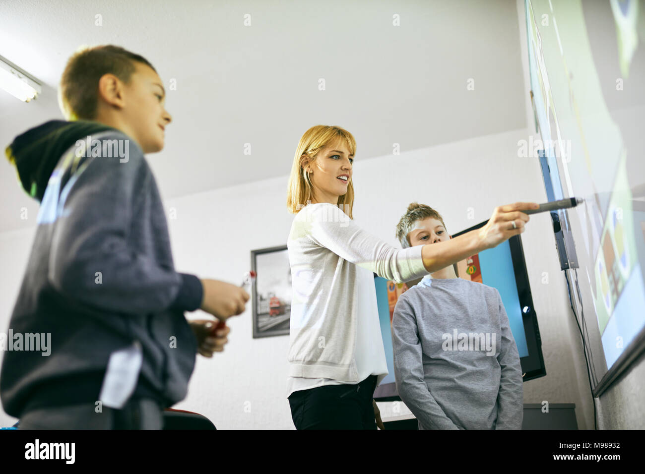 Lehrer mit Schülern im Unterricht am interaktiven Whiteboard Stockfoto