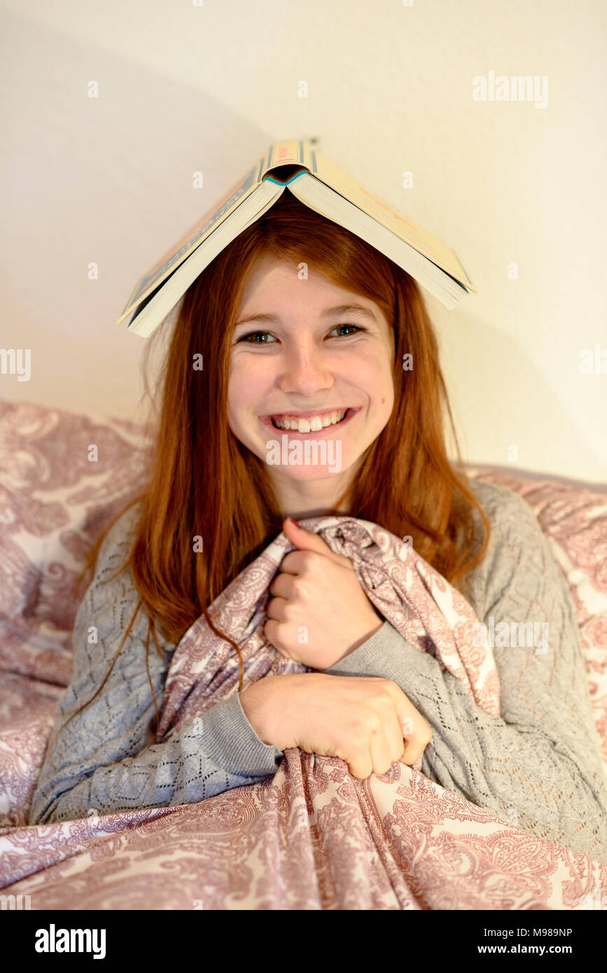 Mädchen mit Buch in Kopf, Bayern, Deutschlaned Stockfoto