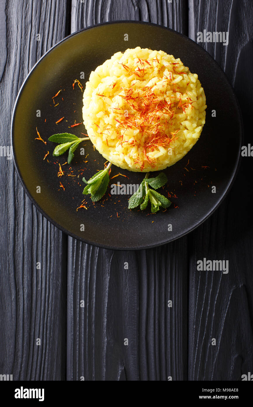 Köstliche italienische Risotto mit Safran und Minze (Risotto alla Milanese) Closeup auf einem Teller. Vertikal oben Ansicht von oben Stockfoto